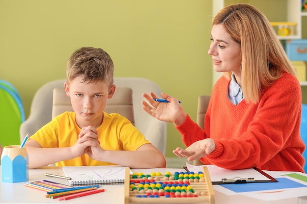 female-psychologist-working-with-boy-suffering-from-autistic-disorder_392895-14282